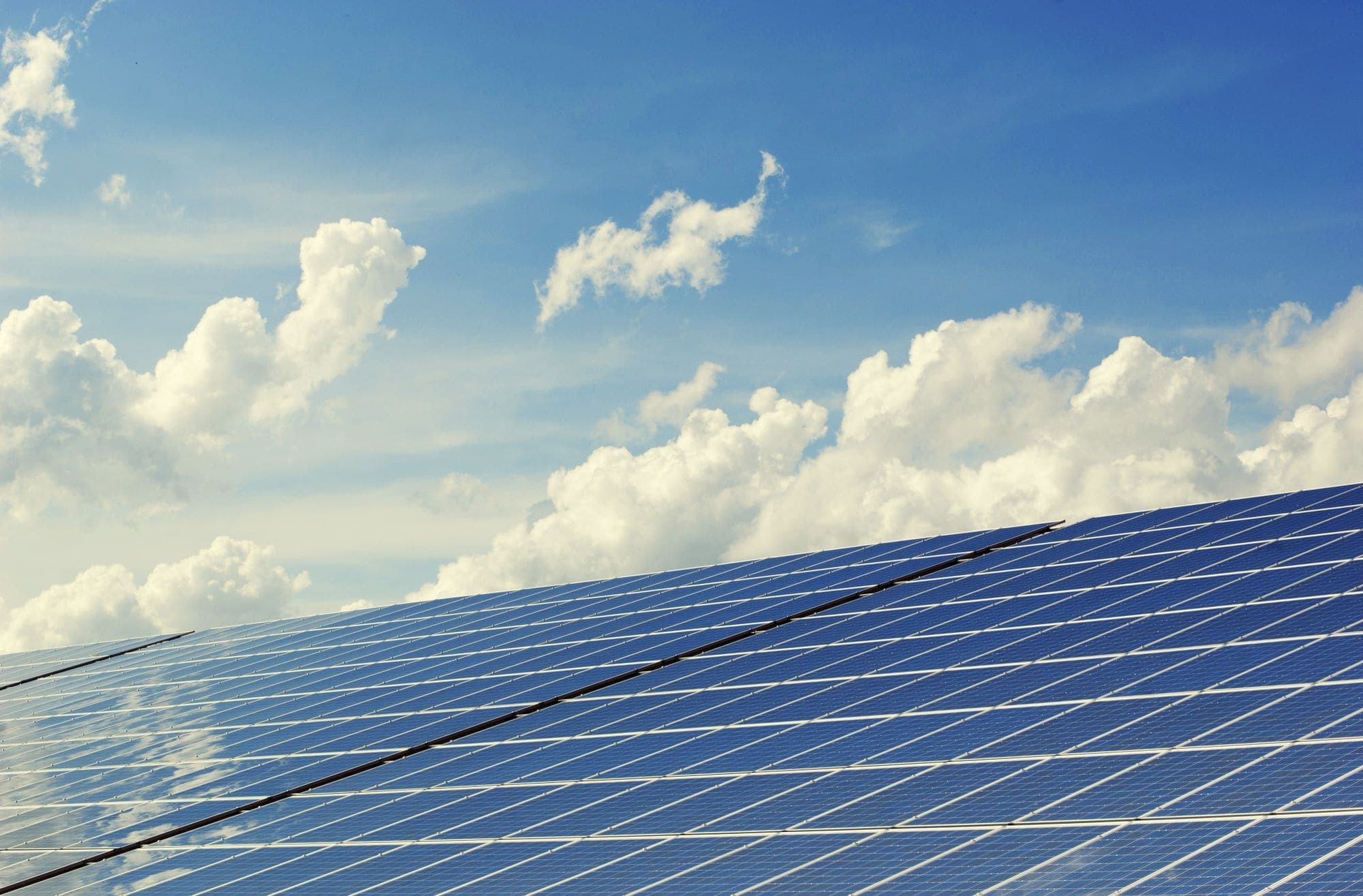 A clean array of rooftop solar panels against a blue sky